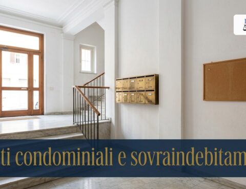 Androne di un condominio con cassette della posta e bacheca vuota: debiti condominiali e sovraindebitamento
