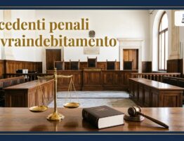 Aula di tribunale vuota con bilancia della giustizia, codice e martelletto: precedenti penali e sovraindebitamento